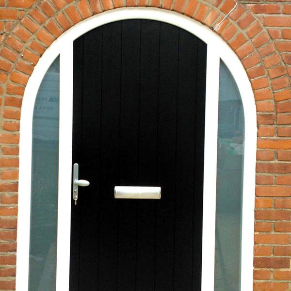 solid black composite door in a large arched frame