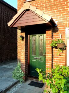 Green composite door with oak upvc door frame and canopy