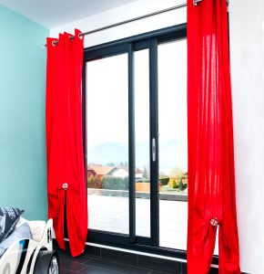 sliding black patio doors with red curtains